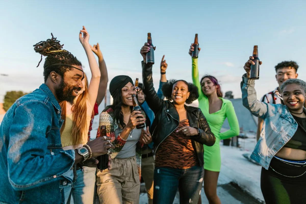 Friends raising drinks together at a rooftop party